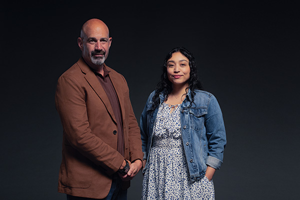 A middle age male and young female Veteran in front of a black background