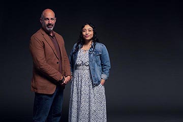 Male and Female Veteran in nice clothes in front of a black background
