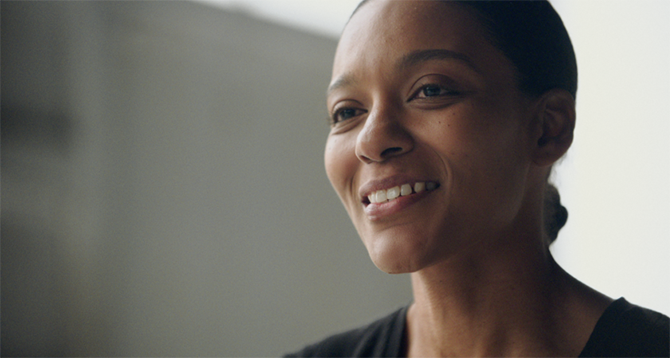 Veteran woman framed to the right smiling and looking off